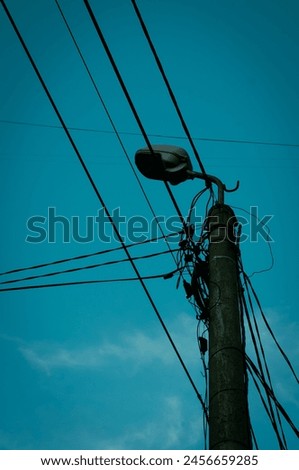 Street lamp and cables with blue sky. Royalty-Free Stock Photo #2456659285