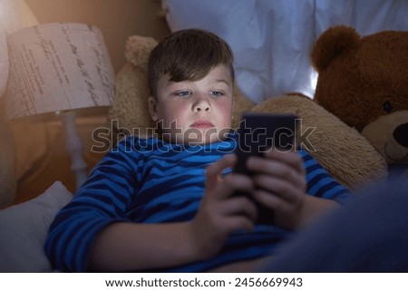 Home, lying and child on smartphone in bed for game, relax and streaming cartoon or movies in bedroom. Young boy, connection and tech in house for learning, education or reading ebook on app online