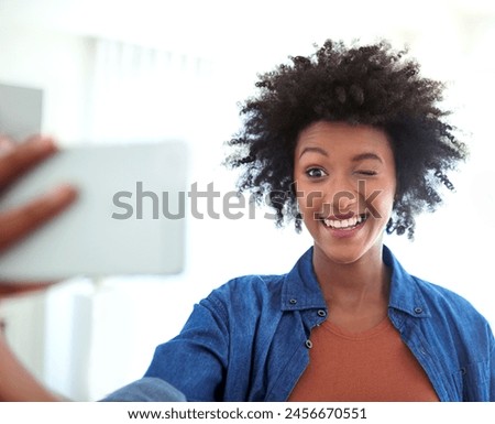 Portrait, woman and selfie with wink in home for social media, profile picture and funny expression. Female person, smartphone and blink emoji for image with fun smile, comedy post and comic online