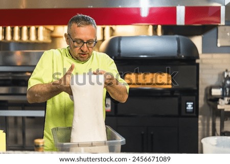 middle age chef working on the pizza dough, pre pizza making process. High quality photo