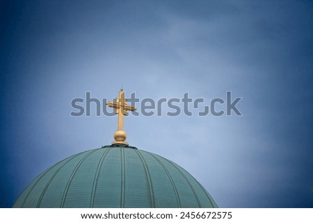 Selective blur on the golden cross on the dome Saint Sava Cathedral Temple (Hram Svetog Save) during a cloudy afternoon. This orthodox church is a monument of Belgrade, part of Serbian Orthodox Church Royalty-Free Stock Photo #2456672575