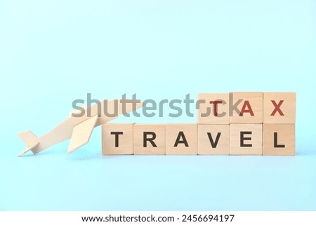 Travel tax concept. Wooden blocks typography on blue background.