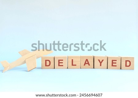 Flight delay concept. Wooden blocks typography on blue background.