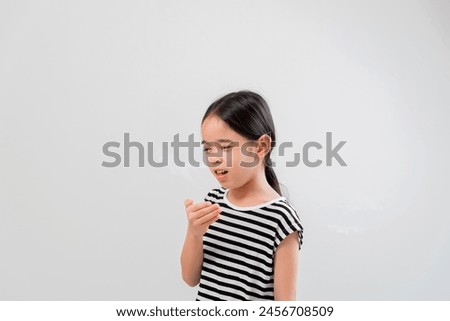 cute Little girl asia sick at home. Cute little girl coughing, covering her mouth with her hand while coughing on white background