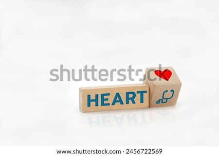 Wooden block with the word HEART and medical icons on the surface. Health care, health insurance and treatment concept.