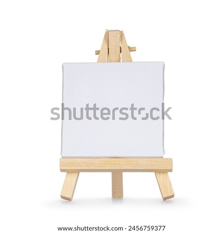 Tiny wooden painters easel with emtpy white canvas, standing facing front. Isolated on a white background.