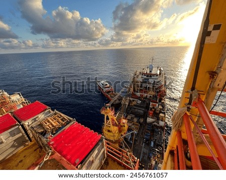 Supply boat capture from oil rig platform with sunset