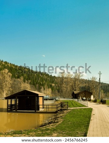 Panorama of the lake and green forest with fir trees in the park in summer in spring. Blue sky. with reflection in water. Park "Red Key" in Russia. Bashkiria. People Walking in the Park