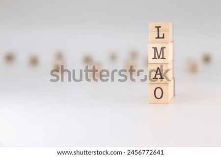 Word LMAO written on wooden cubes isolated on white background . Concept of laughing my ass off