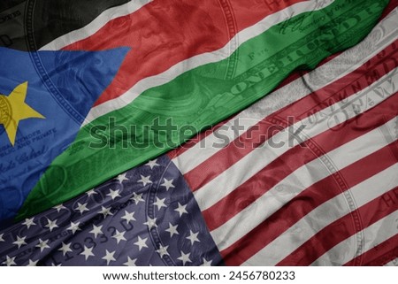 waving colorful flag of united states of america and national flag of south sudan on the dollar money background. finance concept. macro