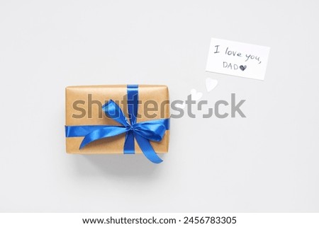 Gift box and paper with text I LOVE YOU, DAD on white background. Father's day celebration. Top view