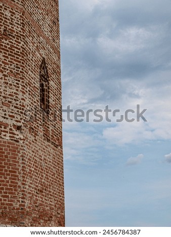 The fortress tower with a loophole is a fragment of the fortress wall Royalty-Free Stock Photo #2456784387