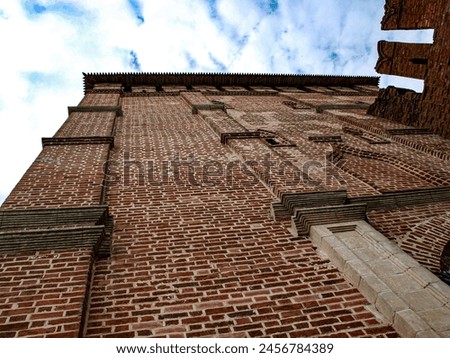 The fortress tower with a loophole is a fragment of the fortress wall Royalty-Free Stock Photo #2456784389