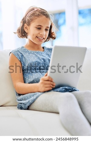 Relax, tablet and happy girl child in home on sofa for game, show or streaming movie online in living room. Kid, smile and digital tech in lounge for download, website and watch cartoon on app