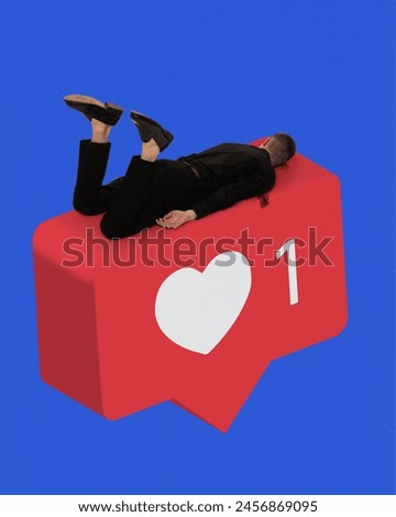 Man in black suit lying upside down on giant red icon, like button against blue background. Contemporary art. Addicted to social popularity. Concept of social media, modern technologies, Internet