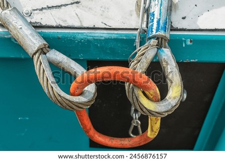 close up of an orange bolt anchor shackle and wire rope sling