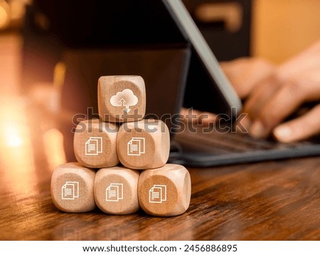 Cloud computing technology management concept. Cloud symbol and digital document file icons on wooden cube blocks pyramid stack near businessman work with tablet computer. Protection and security.
