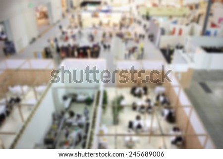 People visit trade show, generic background, humans not recognizable. Intentionally blurred post production.