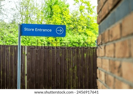 Store entrance signpost with the building in the background