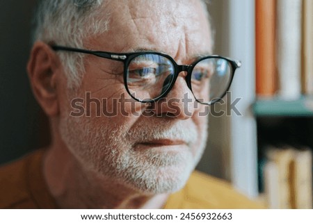 With an aura of scholarly authority, a senior gentleman, adorned with glasses and a beard, commands attention in the bookstore, embodying the essence of lifelong education. Royalty-Free Stock Photo #2456932663