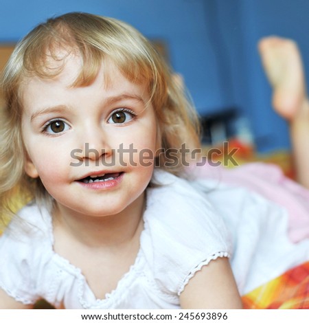  Beautiful little girl lying on bed at house