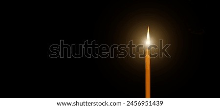 ํYellow candle burns isolate on black background,copy space
