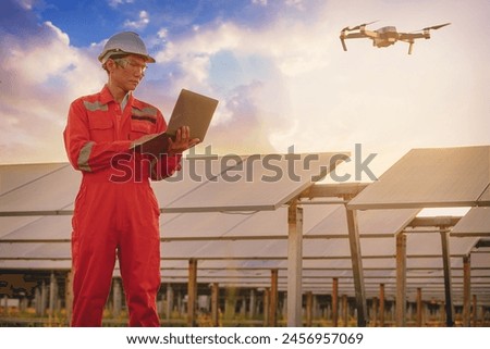 Silhouette of Electrical or instrument technician flying drone for temperature checking and maintenance electrical system at solar panel field.