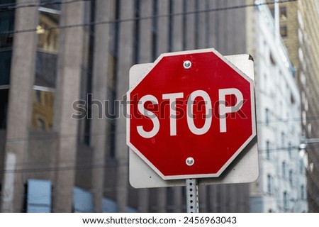 Stop sign between skyscrapers in the city center.