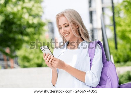 Photo of charming adorable cheerful woman chatting facebook instagram going home after lessons in college summer outside