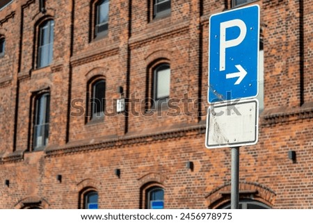 Van parking sign in front of a historic brick warehouse in Bremen, Germany - the van icon is faded and can hardly been seen (translation: "nur" means "only")