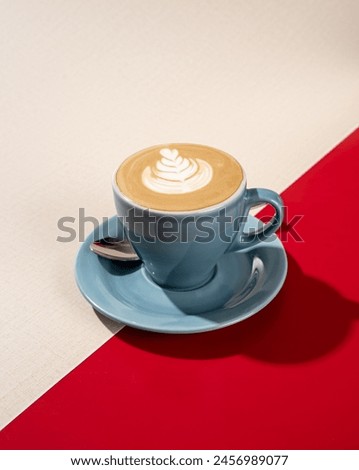 a cup of hot latte coffee on a red and white background