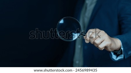 Business people holding magnifying glass on concept of finding something with blank space for copy space.