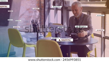 Image of media icons over happy caucasian man using laptop. social media and communication interface concept digitally generated image.