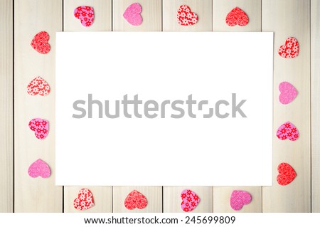 White sheet surrounded by hearts on the background of boards. 