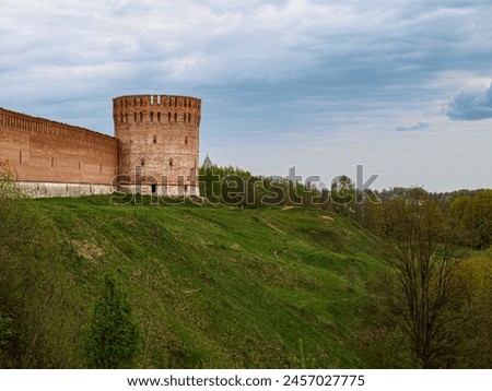 The tower of the old fortress of the early seventeenth century with loopholes and battlements. The line of defense. Royalty-Free Stock Photo #2457027775