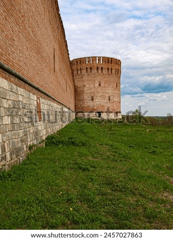 The tower of the old fortress of the early seventeenth century with loopholes and battlements. The line of defense. Royalty-Free Stock Photo #2457027863
