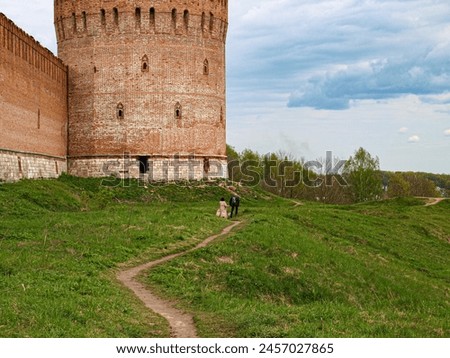The tower of the old fortress of the early seventeenth century with loopholes and battlements. The line of defense. Royalty-Free Stock Photo #2457027865