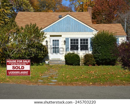 Real Estate sold (another success let us help you buy sell your next home) sign front yard lawn Suburban home sunny autumn fall day residential neighborhood USA