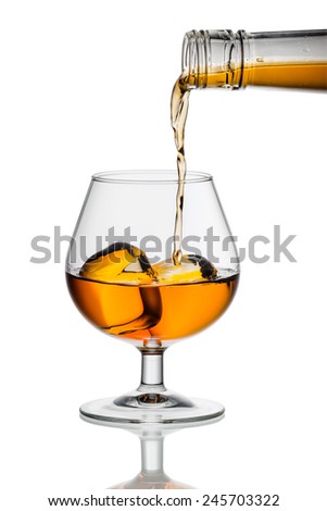 whiskey or brandy being poured into a glass