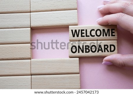 Welcome onboard symbol. Concept words Welcome onboard on wooden blocks. Beautiful pink background. Businessman hand. Business and Welcome onboard concept. Copy space.