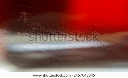 Scratches and dirt on transparent glass on blurred red and dark. Web banner.