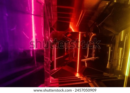Architectural composition of a staircase in a nightlife setting, such as a bar or club. Luminous decoration in the rainbow colors of the LGBTQ+ pride flag
