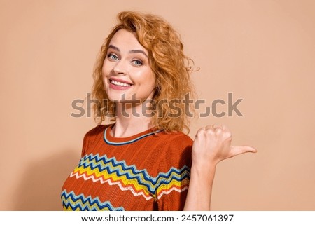 Portrait of good mood adorable girl with foxy hair wear t-shirt indicating at discount empty space isolated on beige color background