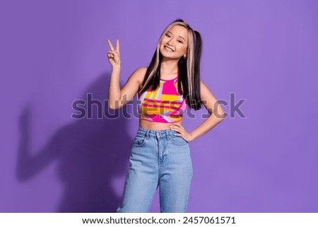 Photo of cheerful positive carefree cute girl wear stylish clothes hand showing v-sign isolated on purple color background