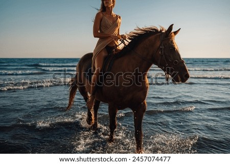 Cropped shot of a beautiful woman taking a romantic horse ride along a sandy shoreline in late afternoon summer sun. Girl enjoying summer on a beach with her rearing stallion.Copy space.