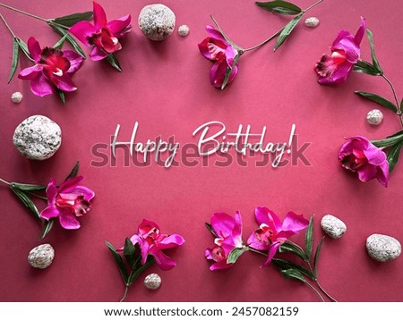 Happy Birthday. Vibrant Orchids and Stones on Pink Background, Festive Greeting Design, Text Happy Birthday.
