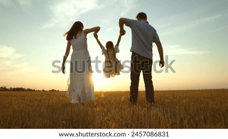 Cute family having fun at sunset, holding hands. Together mom mother daughter kid child dad father walk along field enjoying company weather. Parent girl at nature park. Hope happiness joyful concept
