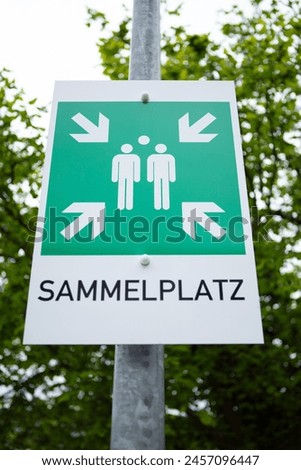 A green sign with the inscription and symbols for a collection point. The word assembly point is written in German.
