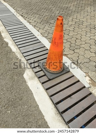 The cone that crosses over the gutter grille is made of iron. With cement block floor.