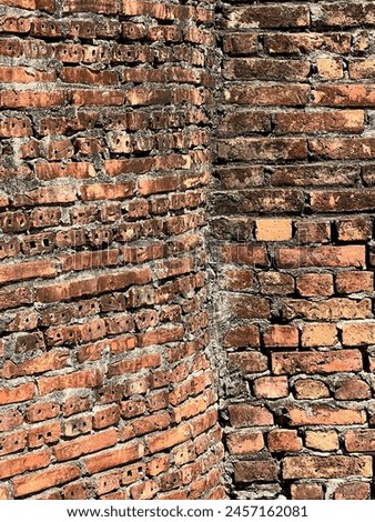 a photography of a brick wall with a fire hydrant in the middle.